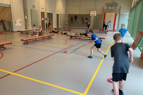 Kinderen die ring hockey aan het spelen zijn. 